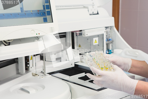 Image of Lab tech loading samples into a chemistry analyzer