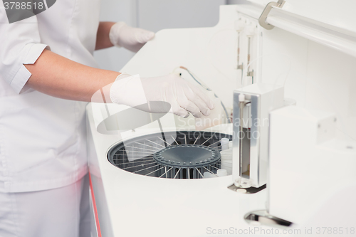 Image of Lab tech loading samples into a chemistry analyzer