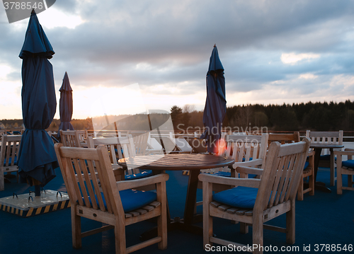 Image of Tables in outdoor bar on stern of cruise liner