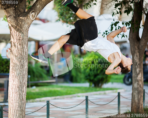 Image of Young athlete doing extreme acrobatics outdoor