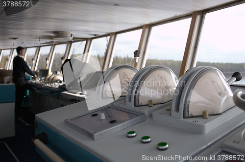 Image of Navigational officer driving ship on the river.