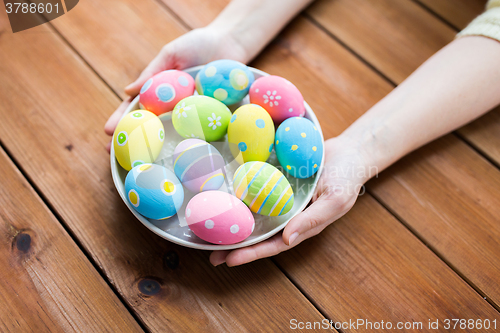 Image of close up of woman hands with colored easter eggs