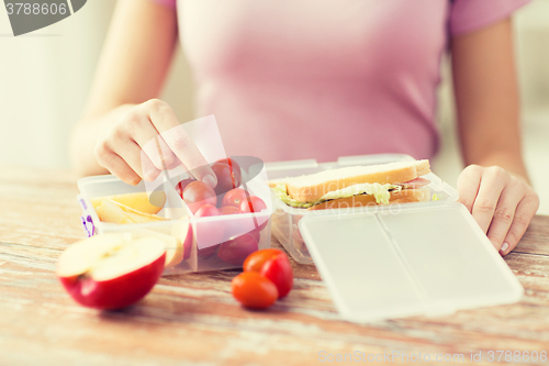 Image of close up of woman with food in plastic container