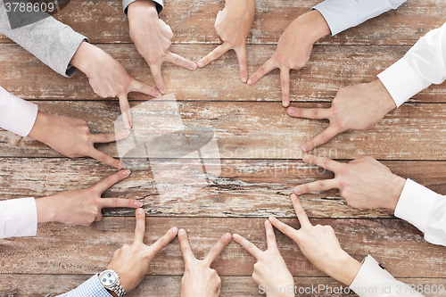 Image of close up of business team showing victory gesture