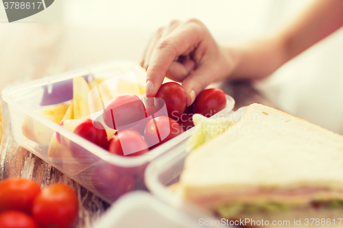 Image of close up of woman with food in plastic container