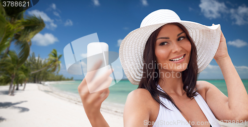 Image of young woman taking selfie with smartphone