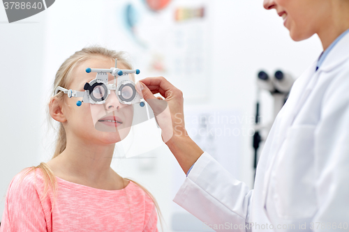 Image of optician with trial frame and girl at clinic