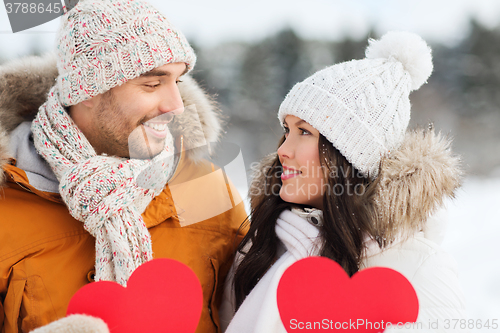 Image of happy couple with red hearts over winter landscape