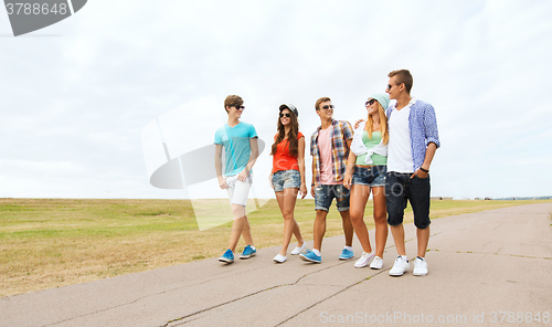 Image of group of smiling friends walking on road