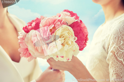 Image of close up of happy lesbian couple with flowers