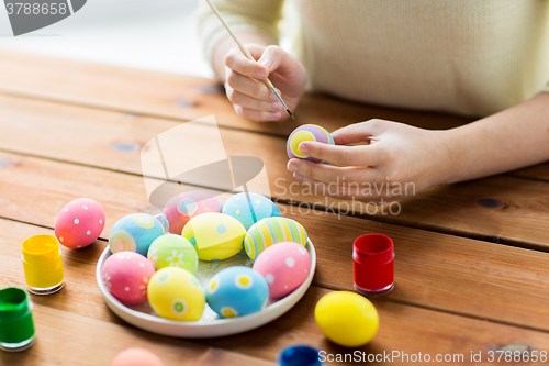 Image of close up of woman hands coloring easter eggs