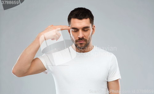 Image of man making finger gun gesture over gray background