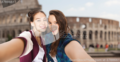 Image of happy teenage girls taking selfie over coliseum