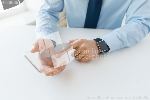 Image of close up of hands with smart phone and watch