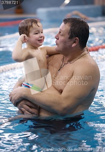 Image of Grandfather playing with his grandson in a swimming pool