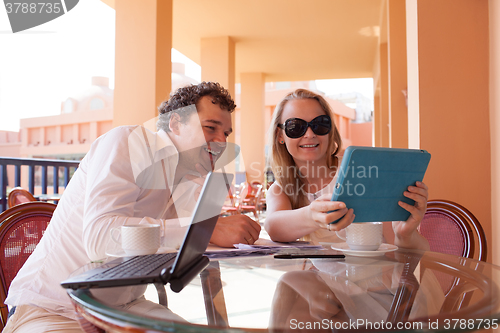 Image of Young couple relaxing over coffee on a balcony