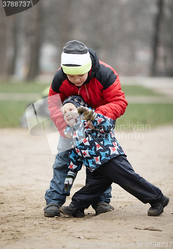 Image of Two young brothers playing outdoors in winter