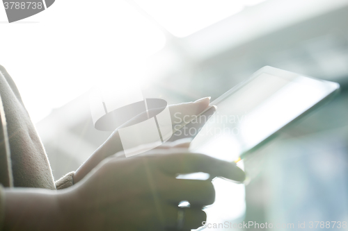 Image of Woman using tablet PC against bright sunlight