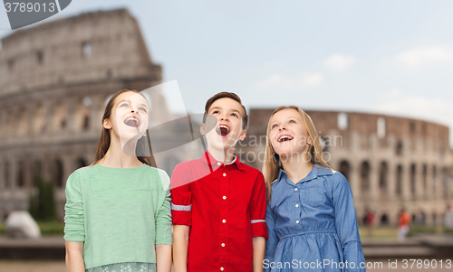 Image of amazed children looking up over coliseum in rome