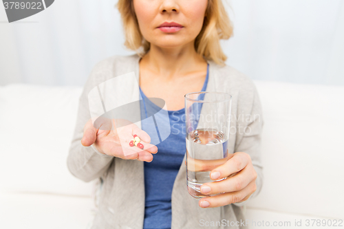 Image of close up of woman with medicine and water glass