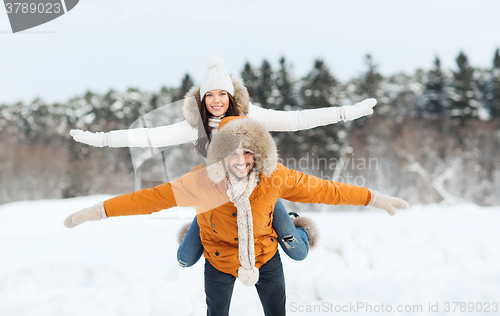 Image of happy couple having fun over winter background