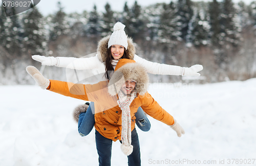 Image of happy couple having fun over winter background