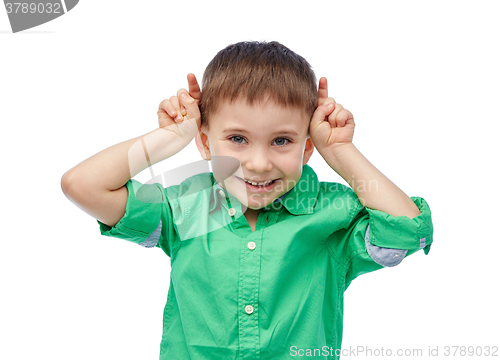Image of happy little boy having fun and making horns