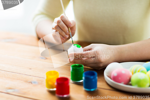 Image of close up of woman hands coloring easter eggs