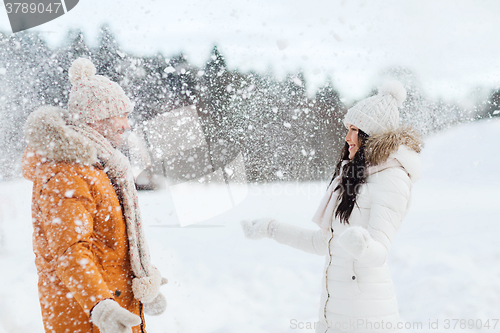 Image of happy couple playing with snow in winter