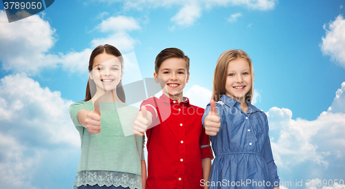 Image of happy children showing thumbs up over blue sky