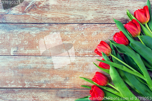 Image of close up of red tulips on wooden background