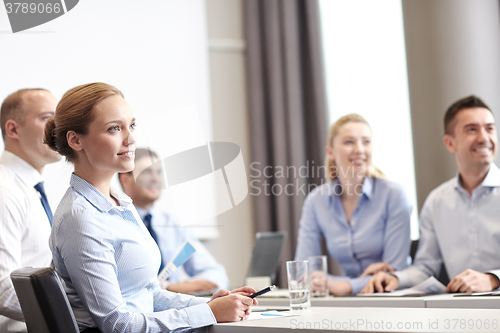 Image of group of smiling businesspeople meeting in office