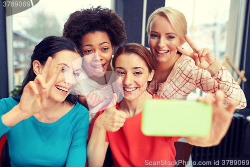 Image of happy young women taking selfie with smartphone