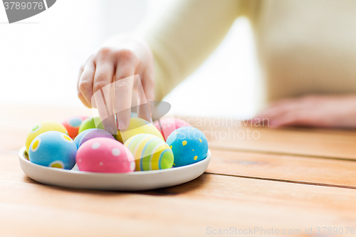 Image of close up of woman hands with colored easter eggs