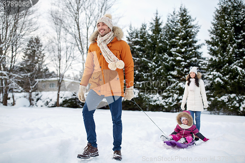 Image of happy family with sled walking in winter outdoors