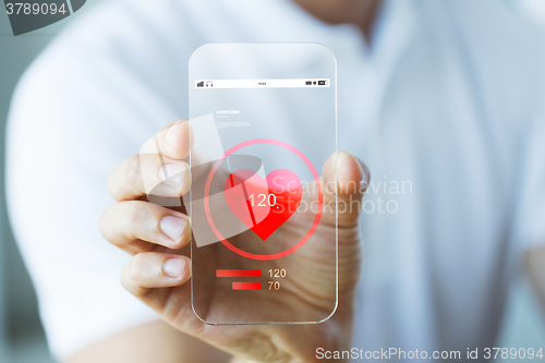 Image of close up of hand with heart rate on smartphone