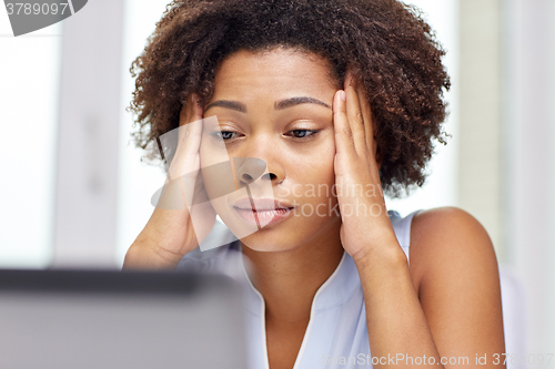 Image of african woman with laptop at office