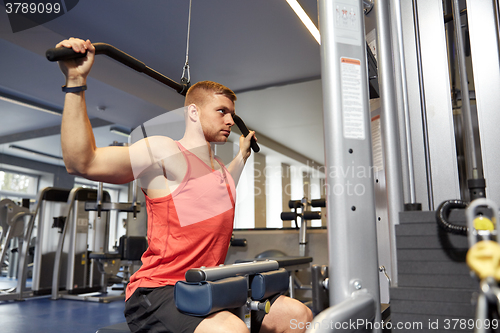 Image of man flexing muscles on cable machine gym