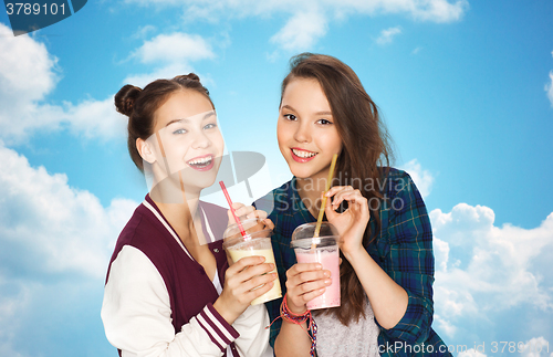 Image of happy pretty teenage girls drinking milk shakes