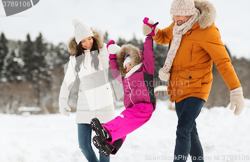 Image of happy family in winter clothes walking outdoors