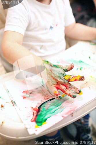 Image of Boy painting with finger-paints