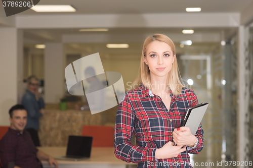 Image of portrait of young business woman at office with team in backgrou