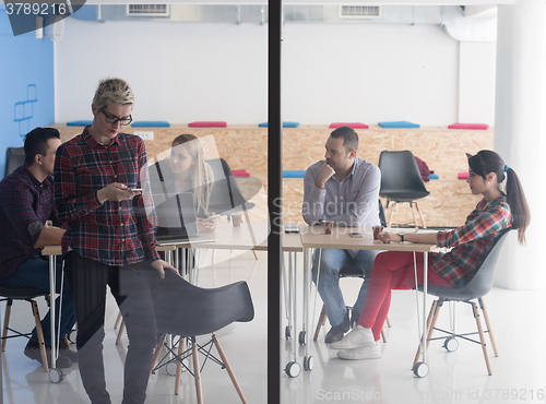 Image of business woman at office speaking by phone  team on meeting in b