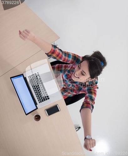 Image of top view of young business woman working on laptop