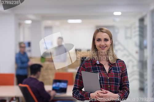 Image of portrait of young business woman at office with team in backgrou