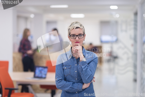 Image of portrait of young business woman at office with team in backgrou