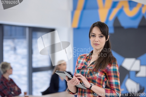 Image of portrait of young business woman at office with team in backgrou