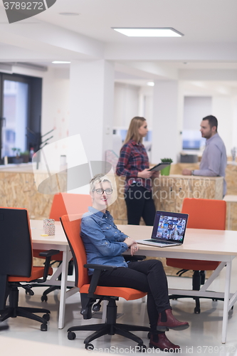 Image of portrait of young business woman at office with team in backgrou