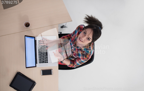 Image of top view of young business woman working on laptop