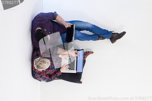 Image of top view of  couple working on laptop computer at startup office